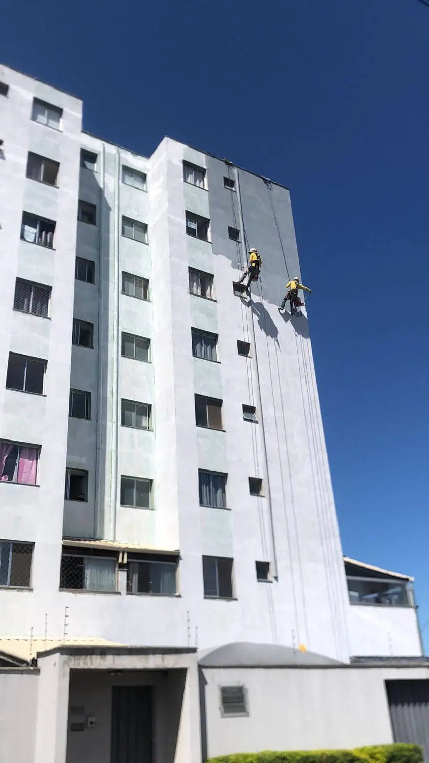 Técnico rapelando na fachada predial